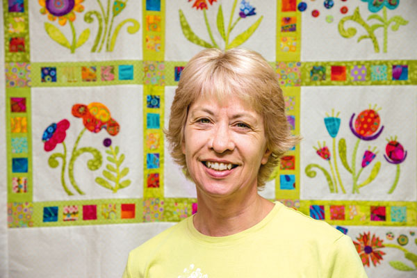 sherry-ellis-in-front-of-one-of-her-appliqued-quilts